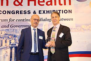 Teva Hesse from C.F. Møller receives the statuette from jury chairman Albert Wimmer - C.F. MØLLER VINNER OSCAR FOR BESTE SYKEHUSBYGG - C.F. Møller. Photo: International Academy of Design and Health